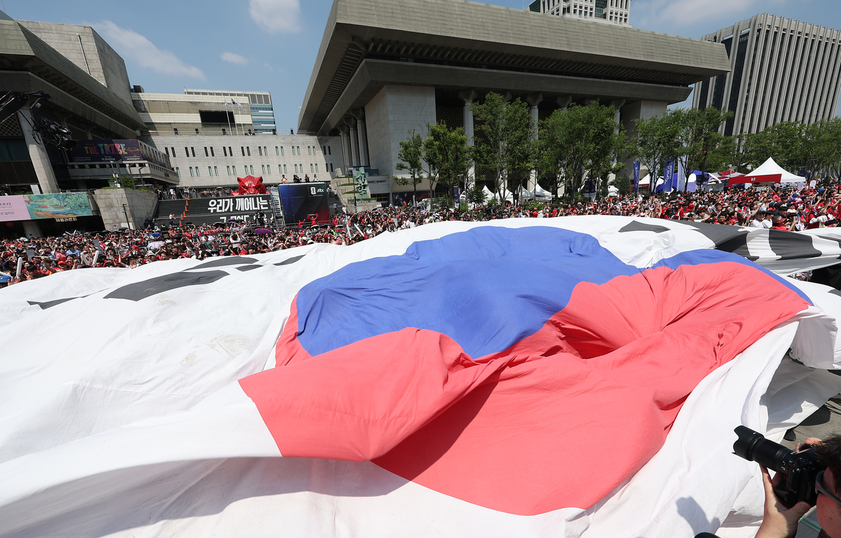 2026 북중미 월드컵 조별리그 A조 한국과 체코의 경기가 열린 12일 서울 종로구 광화문광장에 설치된 축구 거리응원 무대에서 시민들이 대형 태극기를 펼치고 있다. 연합뉴스