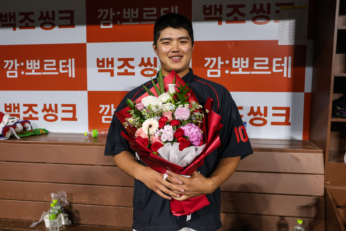 KIA 김태형이 5월26일 고척 키움전에서 데뷔 첫승을 거둔 뒤 축하 꽃다발을 받고 기뻐하고 있다. KIA 타이거즈 제공